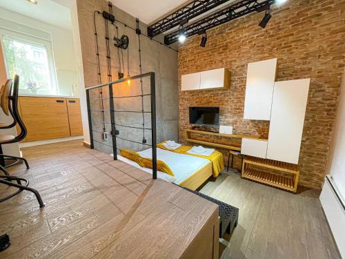 um quarto com uma cama e uma parede de tijolos em Downtown Heaven em Belgrado