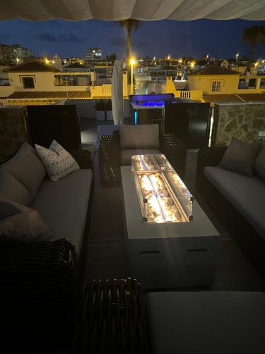 a couch and a table on a balcony at night at PMT22 - Luxury villa with private heated pool and jacuzzi in Torrevieja