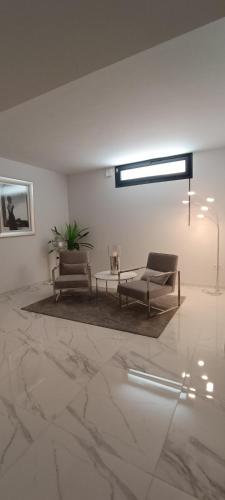 a living room with two chairs and a table at PMT22 - Luxury villa with private heated pool and jacuzzi in Torrevieja
