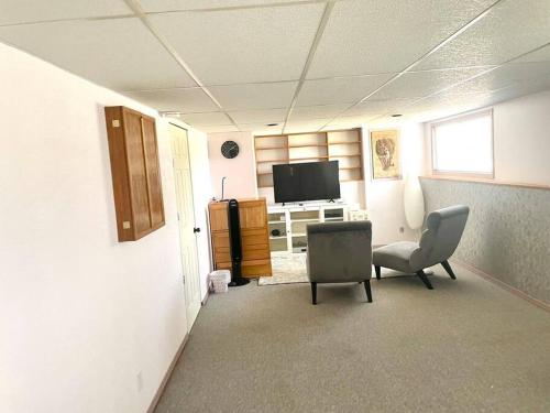 an empty office with two chairs and a television at 2 BD Suite & Separate Entrance West Kelowna in West Kelowna