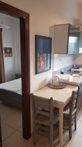 a small kitchen with a table and a bed at Villa Moras in Paralia Katerinis