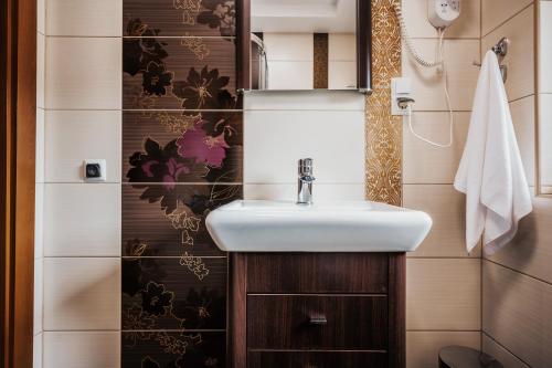 a bathroom with a white sink and a toilet at Apartament pod Nosalem in Zakopane