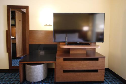 a hotel room with a flat screen tv on a desk at Fairfield Inn & Suites by Marriott London in London