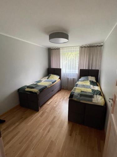 two beds in a small room with wooden floors at Korter Tõrvas Valga mnt 66 in Tõrva
