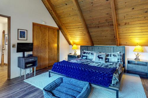a bedroom with a blue bed and a wooden ceiling at House of the Rising Sun in Lake Arrowhead