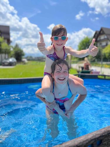 two young girls in the water at a swimming pool at SKALNA CHATA 150 m do Term, Basen in Białka Tatrzańska