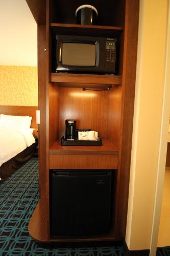a microwave on a shelf in a hotel room at Fairfield Inn & Suites by Marriott London in London