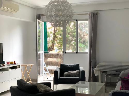 a living room with a chair and a glass table at Entre el verde y el azul in Fuengirola