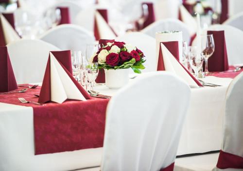 a table with red and white napkins and flowers on it at Hotel Hilling in Papenburg