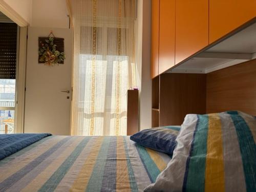 a bedroom with a bed with a striped blanket at OltreMare - San Salvo Marina in Marina di Montenero