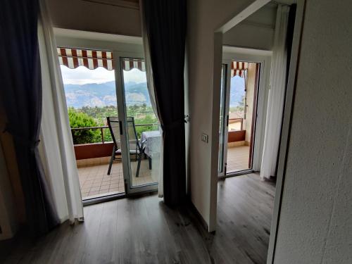 an empty room with a door open to a balcony at Gardesana Active Apartments in Malcesine