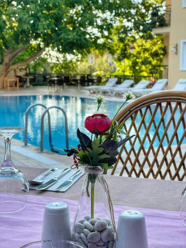 a vase with a flower in it sitting on a table at Güneş Boutique Hotel - Oludeniz in Oludeniz