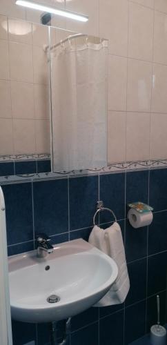 y baño con lavabo blanco y espejo. en Szaffária Apartman Kehidakustány, en Kehidakustány