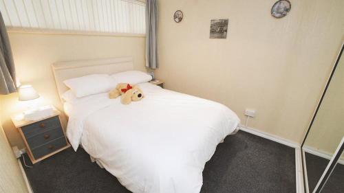 a teddy bear sitting on a bed in a bedroom at Redcliffe Apartments G in Bishopston