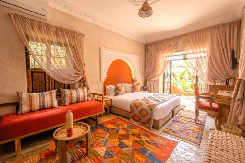 1 dormitorio con cama, sofá y mesa en Le Palais Averroes - Adults Only en Marrakech