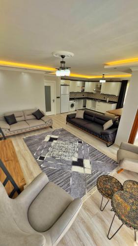 una gran sala de estar con sofás y una alfombra en Sağlam Apart Otel, en Uzungöl