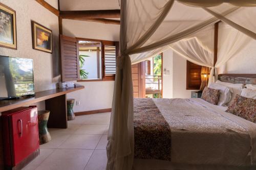 a bedroom with a bed and a television in it at Hotel Villa Balidendê in Barra Grande