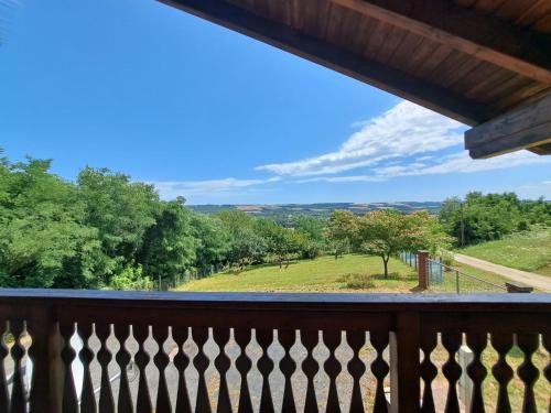 a balcony with a view of a field and trees at Ginkgo House in Kehidakustány