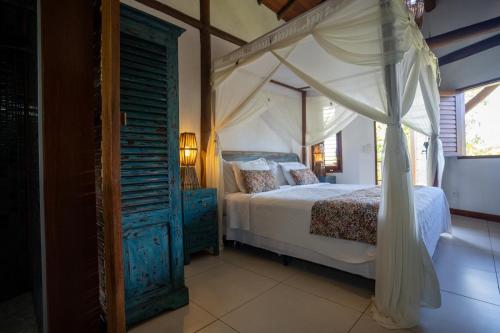 a bedroom with a canopy bed and an open door at Hotel Villa Balidendê in Barra Grande