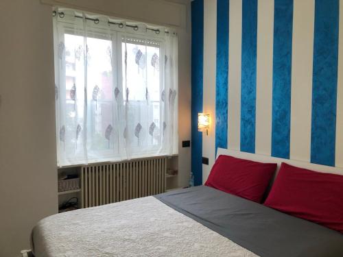 a bedroom with a bed with red pillows and a window at n&ghomesweethome Monet Elegante appartamento casa vacanze - affari in Milan