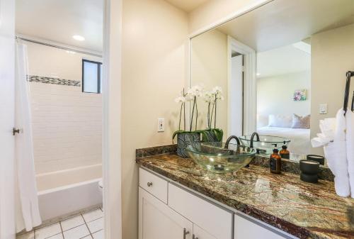a bathroom with a sink and a shower and a tub at Sealodge J8 in Princeville