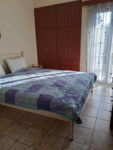 1 dormitorio con 1 cama y armarios de madera en Kali’s comfort, en Karavomylos