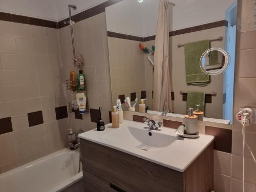 uma casa de banho com um lavatório, um espelho e uma banheira em SALTY SANDY em Lagos