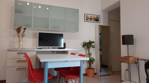 Habitación con escritorio con ordenador y sillas rojas. en Casa Vacanze I Leoni Empoli, en Empoli