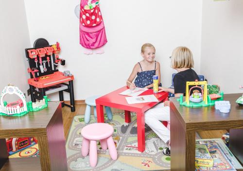 two young girls sitting at a table with toys at Hotel Hilling in Papenburg