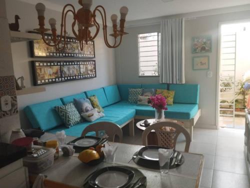 a living room with a blue couch and a table at Flat Villagio Coqueiro in Luis Correia