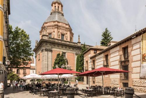 a group of tables and umbrellas in front of a building at Apartamento 1 hab en La Latina - Madrid Centro in Madrid