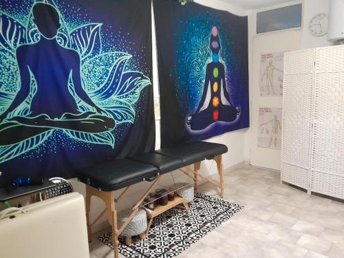 ein Zimmer mit einer Wand mit einem Gemälde einer Person, die Meditation macht in der Unterkunft Casa Relax in Sassari