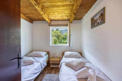 dwa łóżka w pokoju z oknem w obiekcie Holiday home Veki*** w mieście Korenica