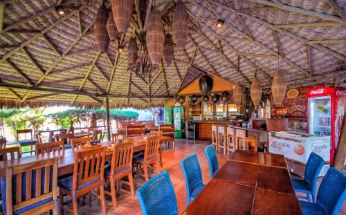 BobZ Boutique Resort, Suíte 21 في بارا غراندي: مطعم بطاولات خشبية وكراسي زرقاء
