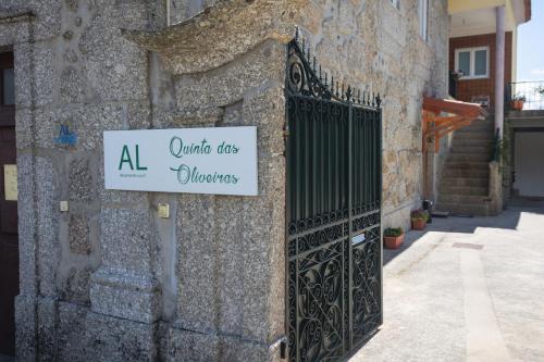 um sinal na lateral de um edifício com um portão de ferro em Quinta das Oliveiras em Arcos de Valdevez
