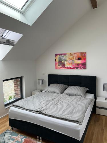 a bedroom with a bed and a painting on the wall at Luxuswohnung Nähe Köln Bonn in Troisdorf