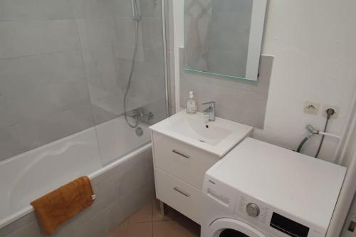 a white bathroom with a sink and a shower at N°1 Annœullin - Appt spacieux - 2 Chambres in Annoeullin