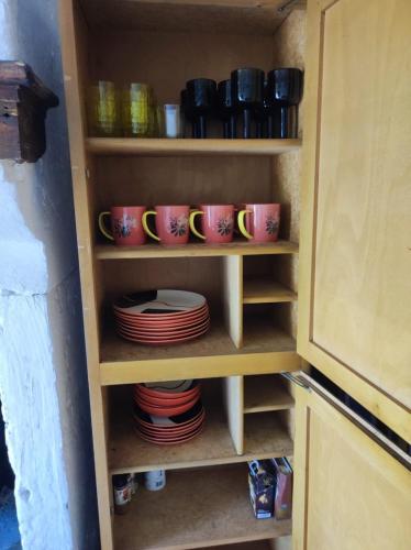 a cupboard full of plates and cups and bowls at maison de vigneron in Mareugheol