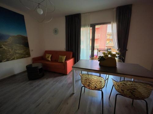 a living room with a table and chairs and a couch at Gardesana Active Apartments in Malcesine