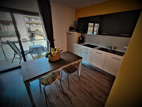 a kitchen with a table and a kitchen with a balcony at Gardesana Active Apartments in Malcesine