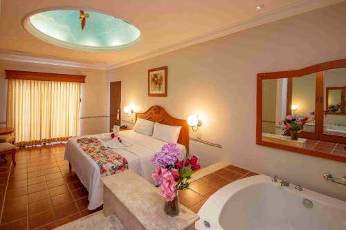 pokój hotelowy z łóżkiem i wanną w obiekcie Hotel del Gobernador w mieście Mérida