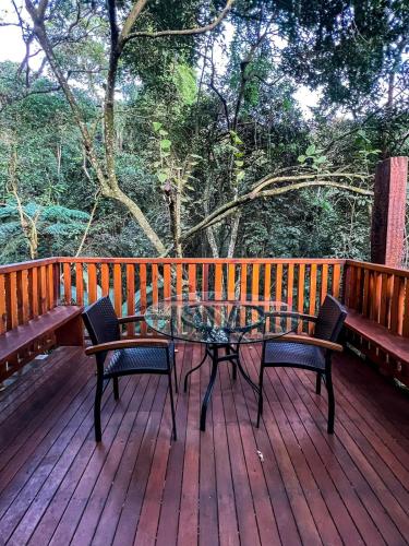 a table and chairs on a wooden deck at Confraria Colonial Hotel Boutique in Mairinque