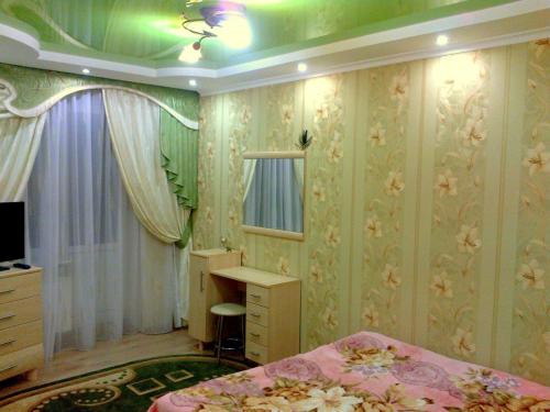 a bedroom with a bed and a dresser and a mirror at Apartments on Proletarskaya in Sumy