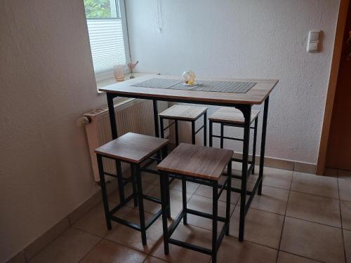 una mesa pequeña y cuatro taburetes en una habitación en Rustikal79 en Bleicherode