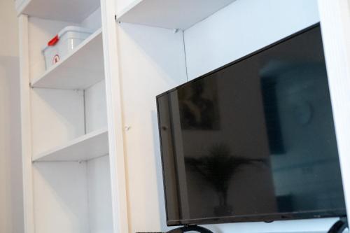 a flat screen tv in a room with shelves at La Casa de Lita in Granada