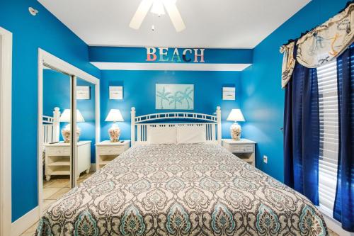 a blue bedroom with a bed and a sign that reads beach at Majestic Beach Towers 2013 in Panama City Beach