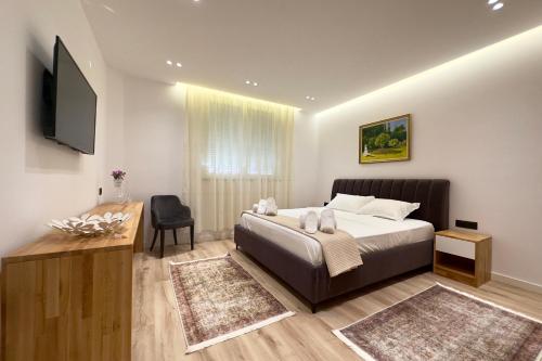 a bedroom with a bed and a flat screen tv at Exquisite by Broci Apartments in Tirana