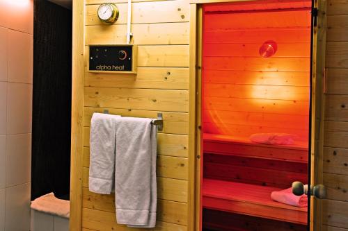 a bathroom with a sauna with white towels in it at B&B Zeespiegel in Zandvoort