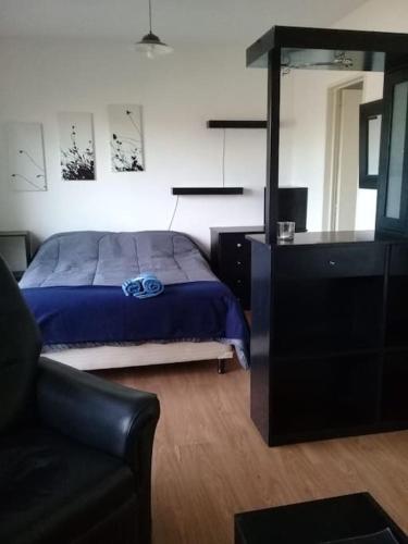 1 dormitorio con cama, sofá y espejo en Monoambiente en zona norte en Martínez