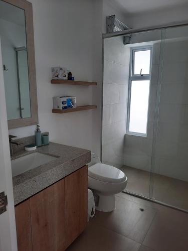 e bagno con servizi igienici, lavandino e doccia. di Loft acogedor con área de parrilla y piscina a Punta Hermosa